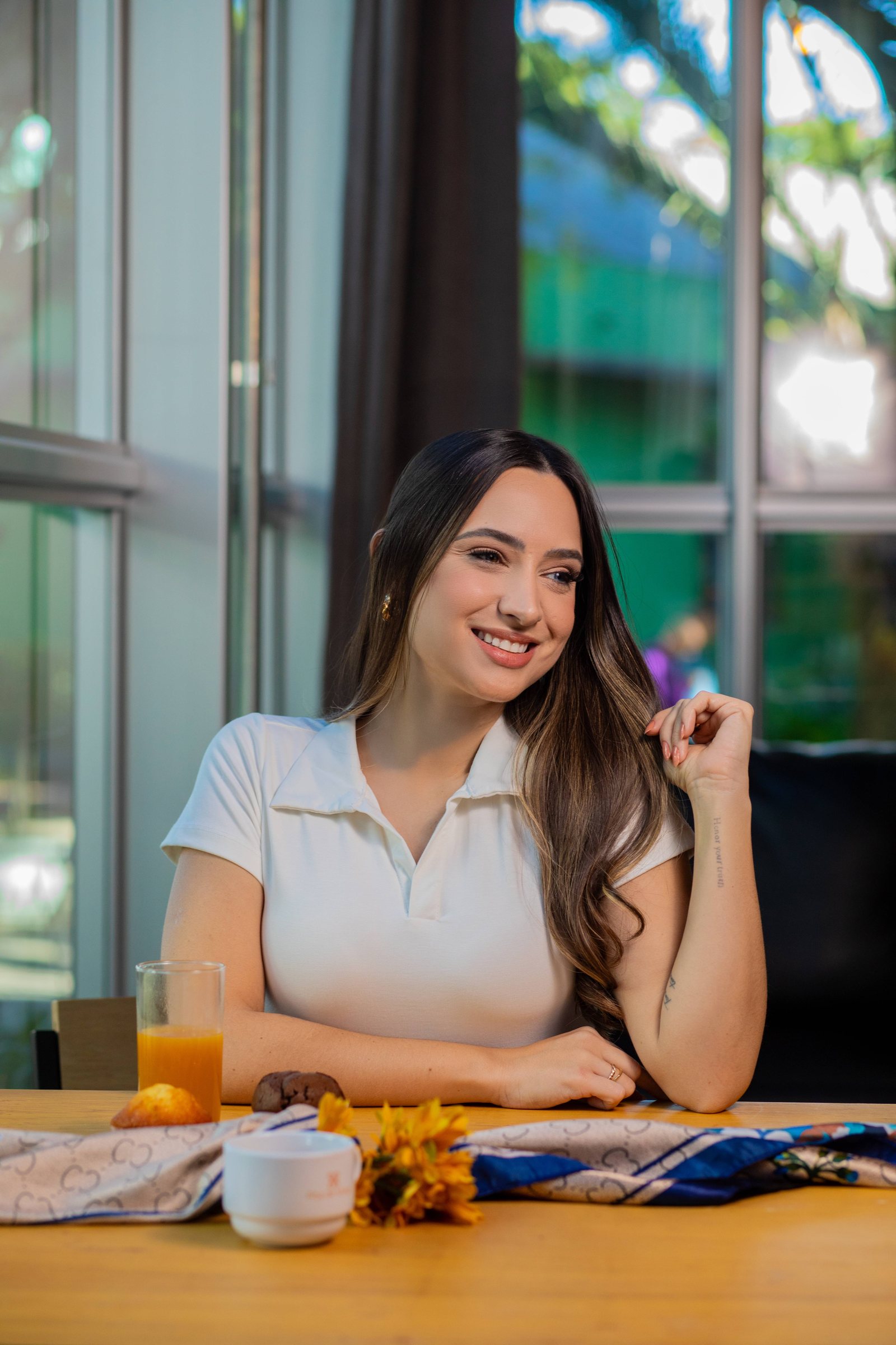 Regata branca e calça areia à mesa de café