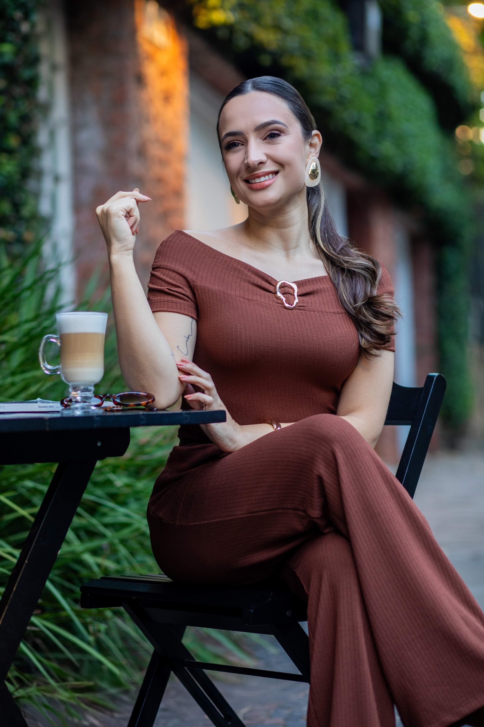 Conjunto marrom off-shoulder sentada em café