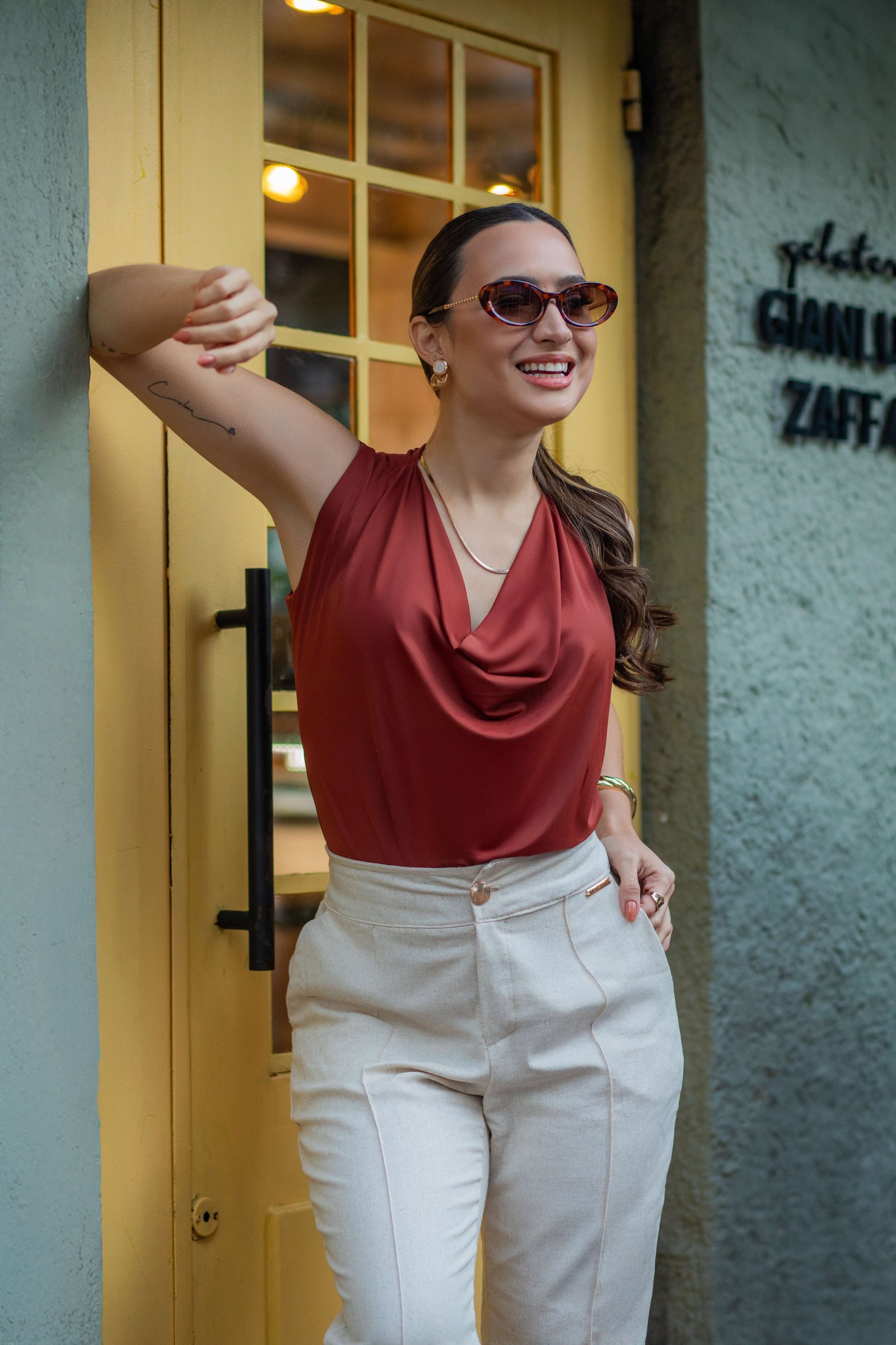 Blusa terracota e calça areia em porta amarela